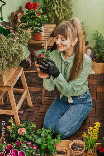 Young Woman Planting Flowers at City Balcony (ID: 789194025)