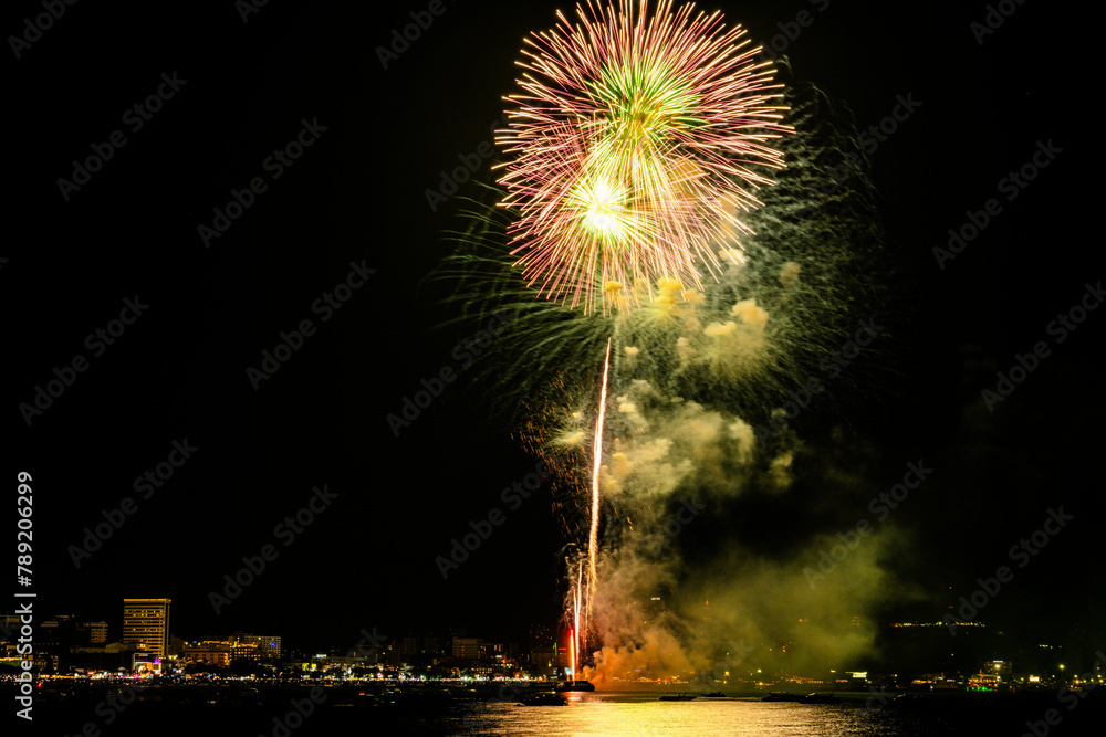 Breathtaking fireworks light up the night sky above a tranquil bay, casting reflections over calm waters. Breathtaking fireworks light up the night sky above a tranquil bay, casting reflections over calm waters.