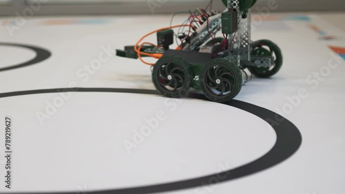Robot goes through development test maneuvering with precision. Robot with wheels conducts series of tasks and challenges at demostration photo