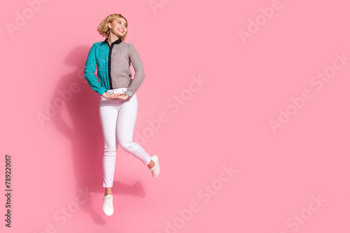 Full size photo of pretty young girl jump elegant look empty space wear trendy striped cyan outfit isolated on pink color background