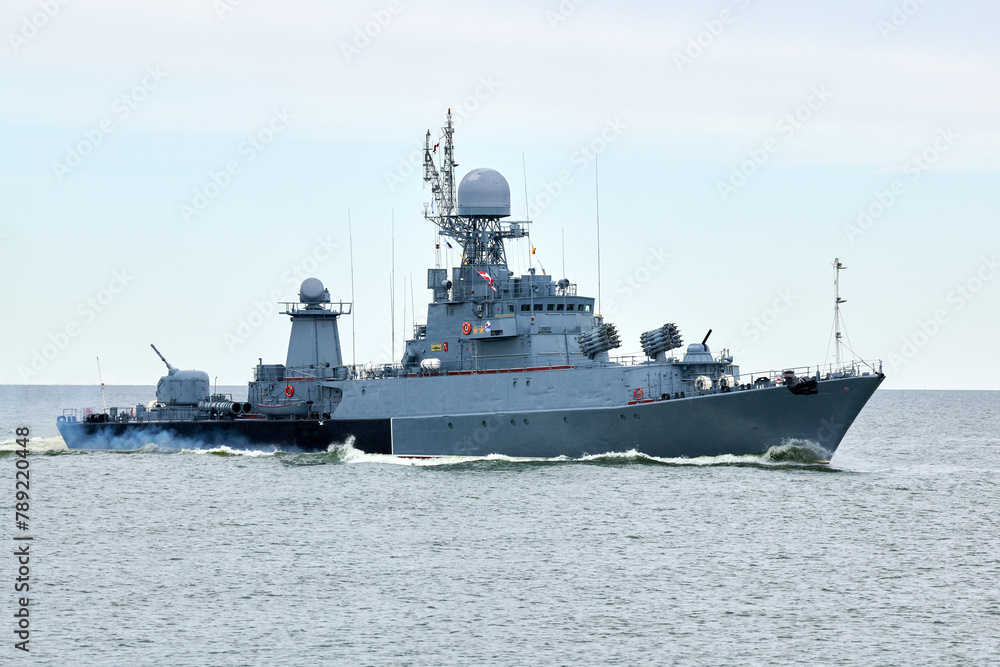 Russian warship armed with armament sails into sea toward military target to attack and destroy enemy, military ship performing strategic maneuver, Russian sea power deployment for tactical advantage