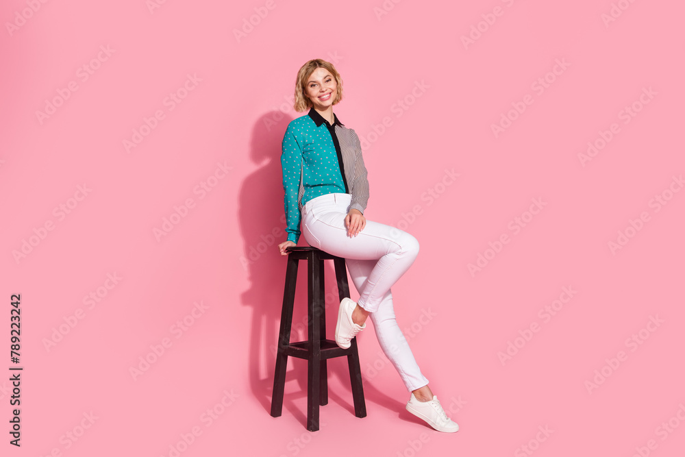Full size photo of pretty young girl girlish posing model sit chair wear trendy striped cyan outfit isolated on pink color background Full size photo of pretty young girl girlish posing model sit chair wear trendy striped cyan outfit isolated on pink color background