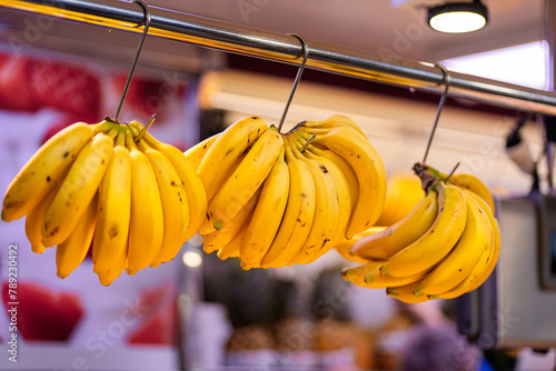 Fresh bananas hanging at a vibrant fruit market photo