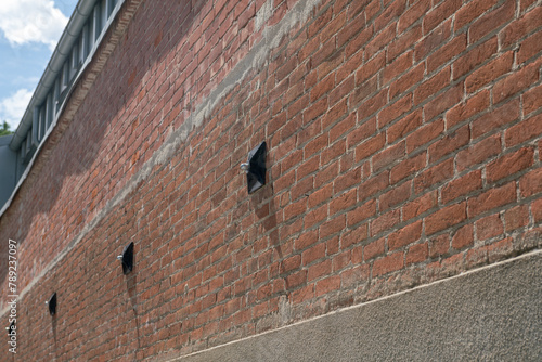 Tie rod on the wall of an exposed brick building with construction detail of the keys supporting the internal tie rods, key - counterthrust chain for a renovated building.