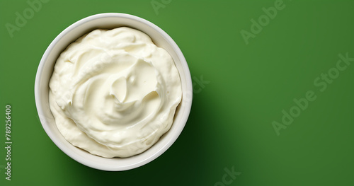 Top view of bowl with white quark or cream on side of green background with copy space сreated with Generative Ai photo