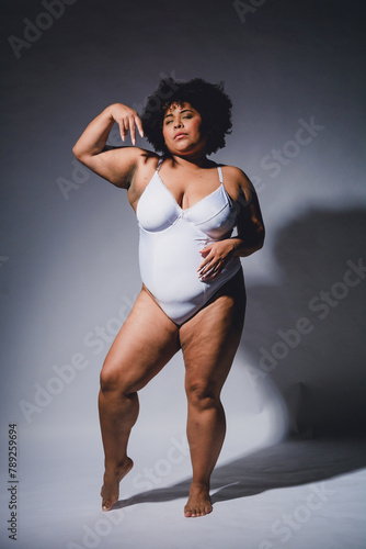 young woman posing in white lingerie confident and empowered, studio shot.
