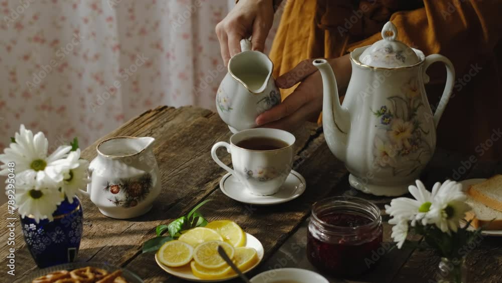 Tea party in rustic style. Pouring milk into tea cup. Tea party in rustic style. Pouring milk into tea cup.