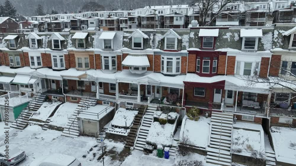 Aerial flight towards row of houses in low income housing area of american city. Cold snowy winter day in America. Snowfall in poor suburb district. Aerial flight towards row of houses in low income housing area of american city. Cold snowy winter day in America. Snowfall in poor suburb district.