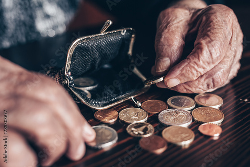 Detailed closeup photo of elderly 96 years old womans hands counting remaining coins from pension in her wallet after paying bills. Unsustainability of social transfers and pension system