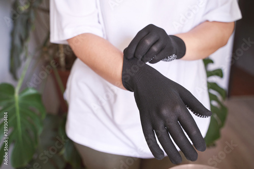 The hand wearing a rubber glove. Symbolizing safety in work. It conveys approval and positive communication. Satisfaction and protection. Putting on hand