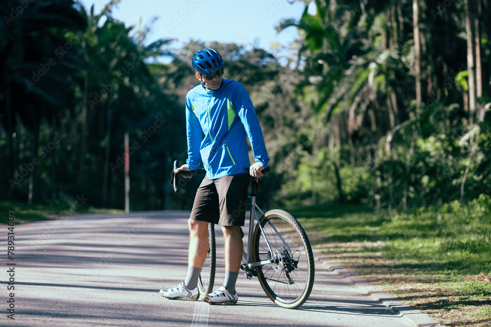 Fototapeta premium Cyclist rides through the park on a summer day.