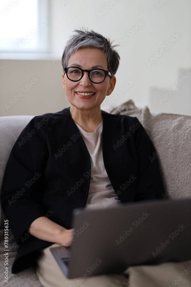 An elderly woman enjoys using her laptop for internet communication, embodying a happy and confident lifestyle at home. An elderly woman enjoys using her laptop for internet communication, embodying a happy and confident lifestyle at home.