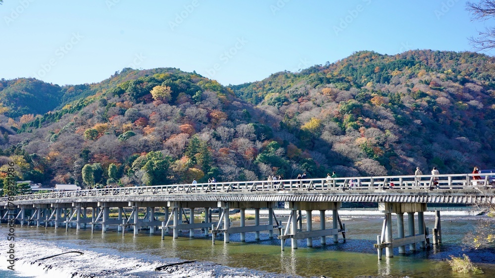 View of The Togetsukyo Bridge, Arashiyama, Kyoto, Japan, in autumn. Clear blue sky. lake and mountains