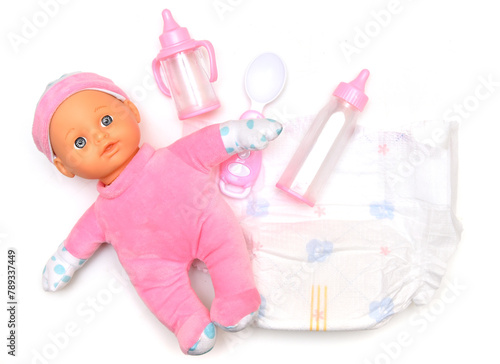 Baby doll, diapers, pacifier and bottles for feeding a baby on a white background. Taking care of the child.