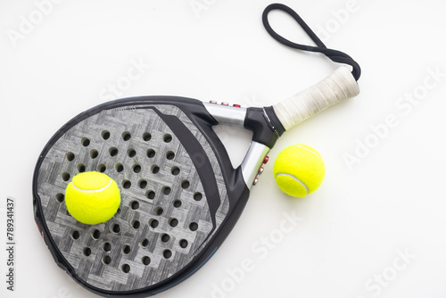 Set of paddle tennis rackets and balls the reflected on white table and white isolated background. Front view.