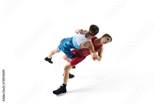 Young male athletes, concentrated wrestlers in motion, competing, demonstrating agility and technique isolated on white background. Combat sport, martial arts, competition, tournament, athleticism