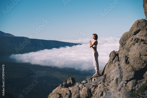 Woman doing yoga and meditating on background of natural landscape photo