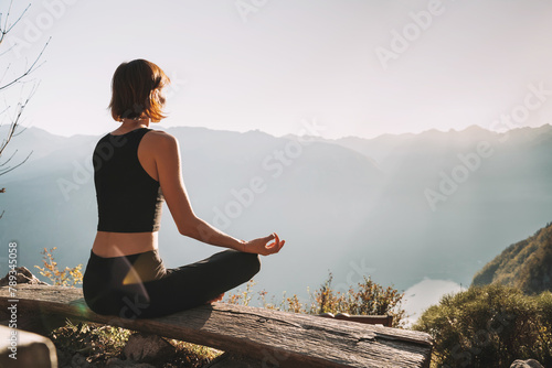 Young woman is meditating in mountains. photo