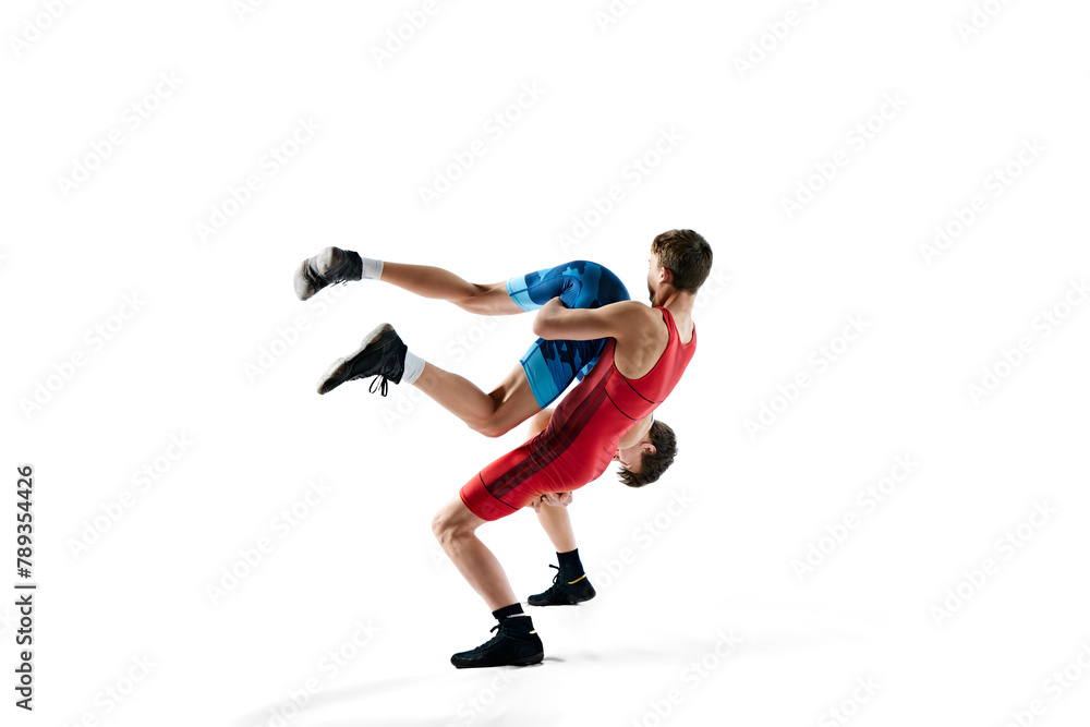 Young men, wrestlers showing athleticism and determination as they grapple isolated on white background. Concept of combat sport, martial arts, competition, tournament, dynamics