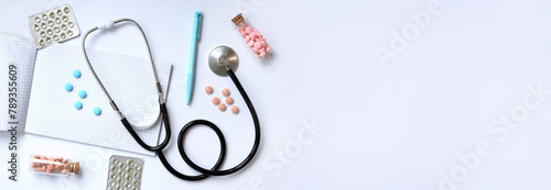 Stethoscope, notepad and pen on a light background, top view. Cardiology and healthcare concept. Auscultation apparatus. Medical care concept. Stethoscope and medicines. Therapist's desk