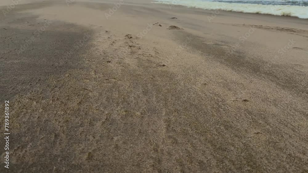 A storm wind carries sand along the sea beach A storm wind carries sand along the sea beach