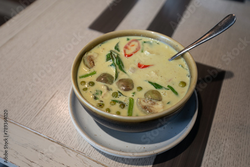 Close up shot of green curry with rice served on a table