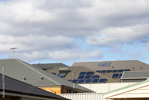 suburban roofs with solar hot water systems, tv antennae and photovoltaic solar panels photo