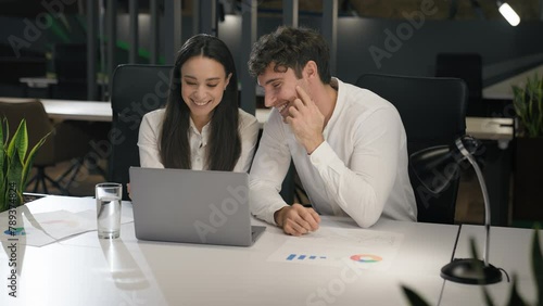 Cheerful Caucasian talking smiling laughing with laptop computer pc in office colleagues male manager and female businesswoman at desk working discussing project together having fun corporate business