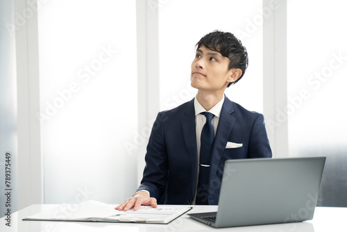 ノートパソコン入力作業中に決意する男性ビジネスマン