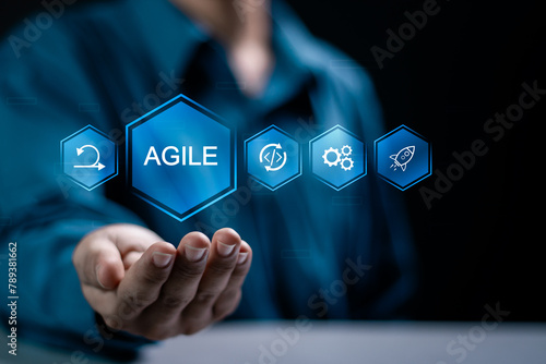 Agile development methodology concept, businessman holding agile icon on virtual screen for process that will help you work faster By reducing step-by-step work and focusing on team. photo