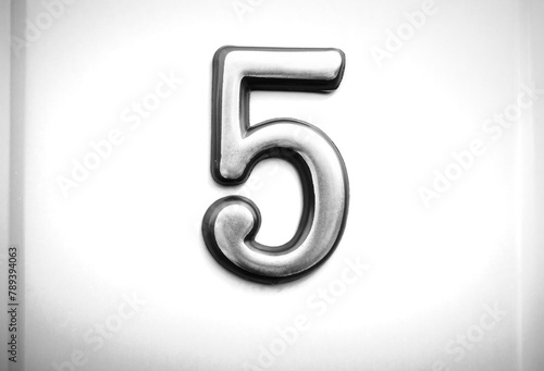 Black & white steel plaque with number FIVE object backdrop