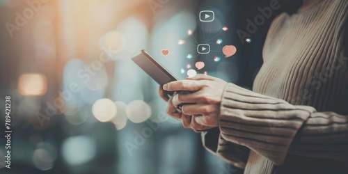 woman's hands using a phone while the social media icons float on the screen, photo