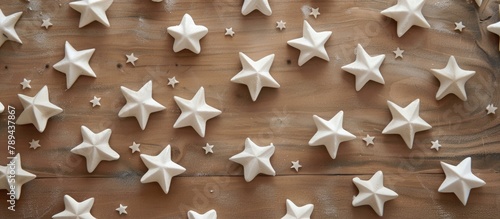 White gypsum stars are arranged on the table in a decorative handmade pattern, seen from above in a flat lay perspective. photo