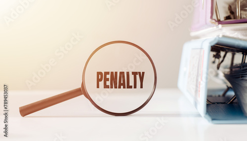 A magnifying glass hovering over a business background with the word PENALTY displayed prominently underneath.