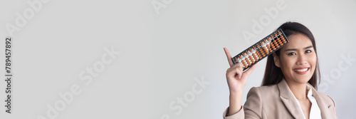 Corporate office worker or business woman holding Japanese abacus and pointing up, concept image of mental math, fast calculation training, Accounting with precise number calculation, financial worker