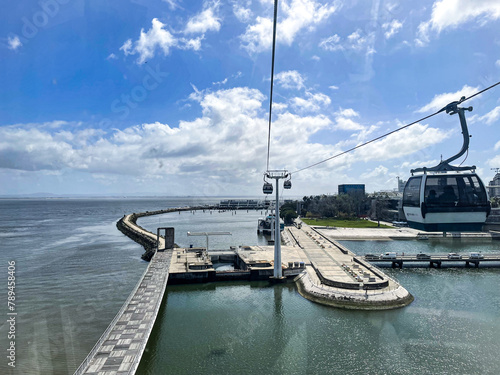 Lisbon, Portugal - April 10, 2024: Telecabine Lisboa in the Park of Nations. Vasco da Gama Tower and Bridge in Lisbon. A cable car in Lisbon's modern neighborhood over the Tagus River