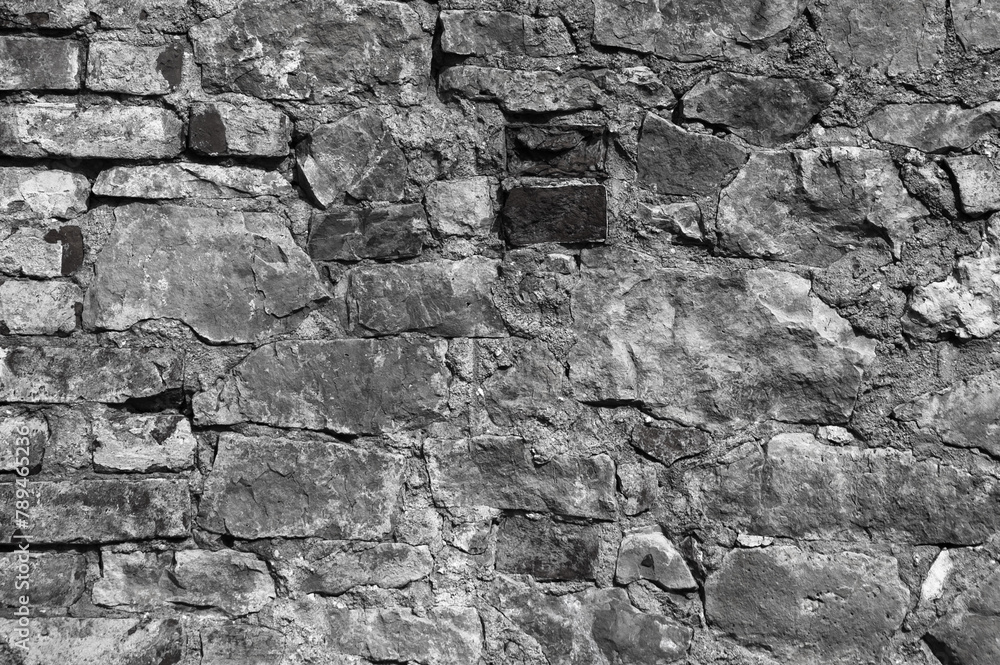 in the photo there is an old gray stone wall close up in the photo there is an old gray stone wall close up