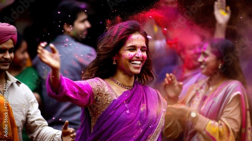 A beautiful Indian woman in a purple sari, smiling and throwing colored powder at the holi festival with friends around her