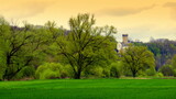 schöne Burg im grünen Lahntal im Frühling unter malerischem gelblichem Himmel
