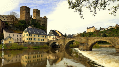 alte Burg Runkel über der Lahn mit Wasserfall und alter Bogenbrücke unter sonnigem Himmel photo