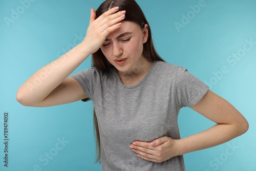 Woman having heart attack on light blue background