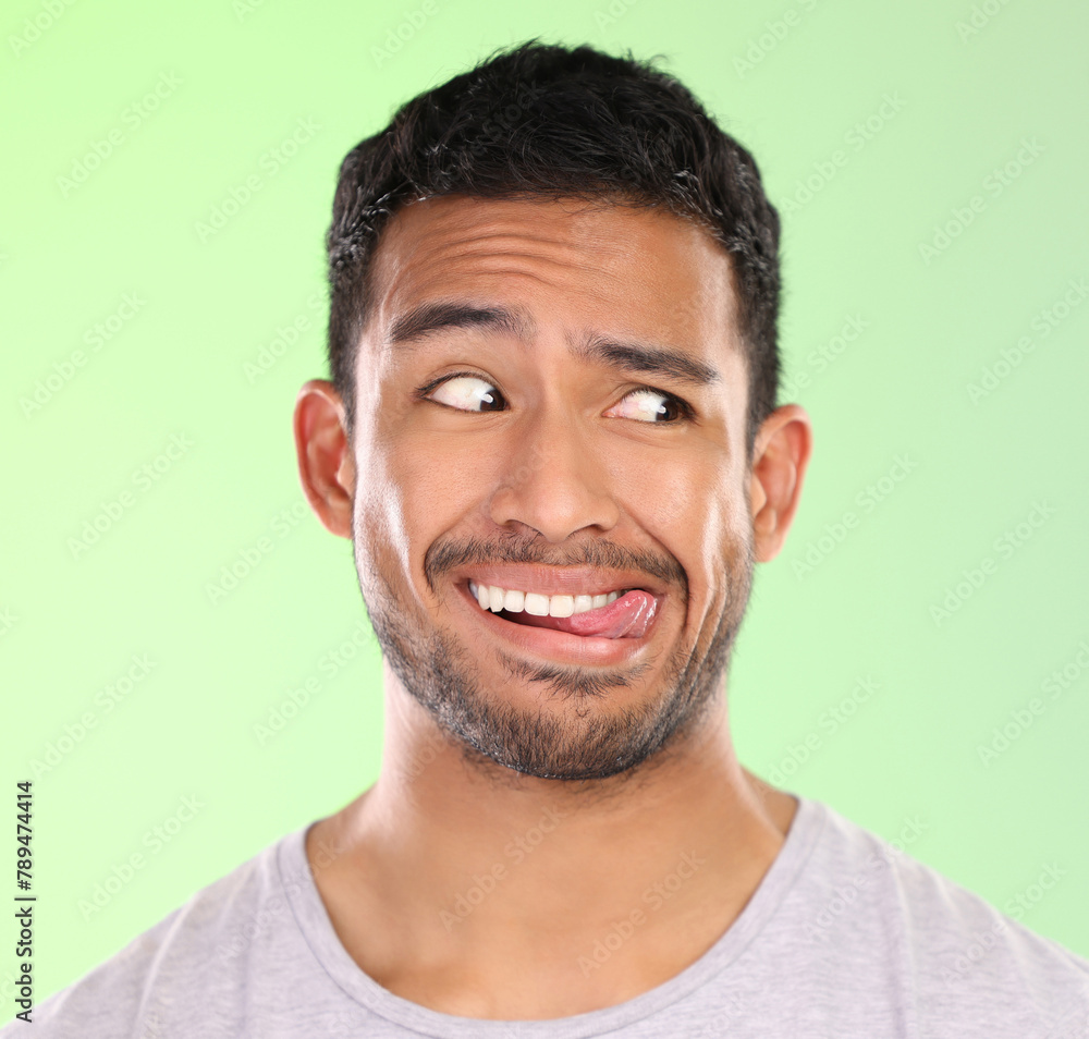 Man, play and silly in studio, tongue and goofy comic or funny face on green background. Male person, mockup space and awkward for joke or comedy, student and humor for crazy character and quirky Man, play and silly in studio, tongue and goofy comic or funny face on green background. Male person, mockup space and awkward for joke or comedy, student and humor for crazy character and quirky