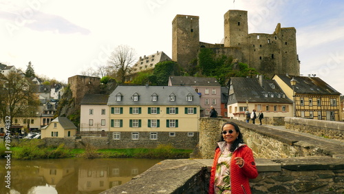 charmante junge Frau steht auf Brücke über der Lahn vor alter Burg Runkel photo