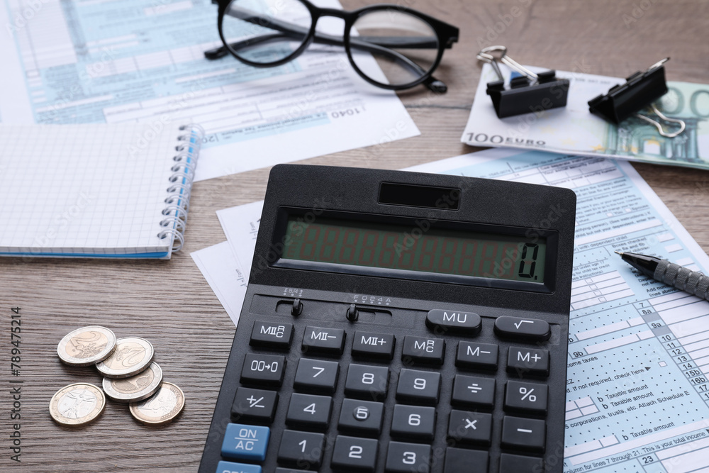 Tax accounting. Calculator, documents, stationery and glasses on wooden table, closeup Tax accounting. Calculator, documents, stationery and glasses on wooden table, closeup