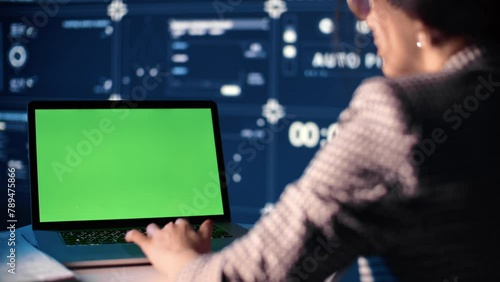 Muslim woman engineer working with laptop in modern office, closeup view of green screen of computer