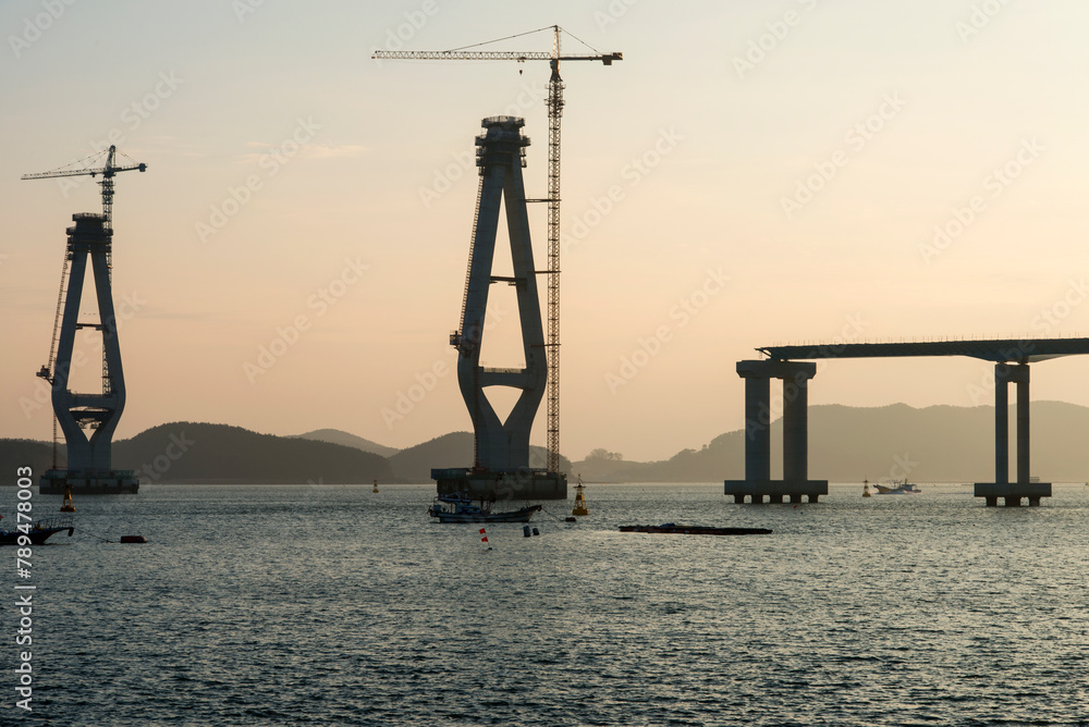 constructing the bridge on the sea during sunset