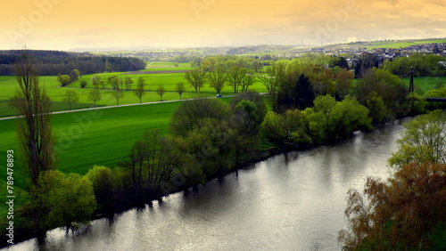 Fluss Lahn im grünen Tal bei Limburg im Frühling bei gelbem Sonnenschein und Spiegelung im Wasser