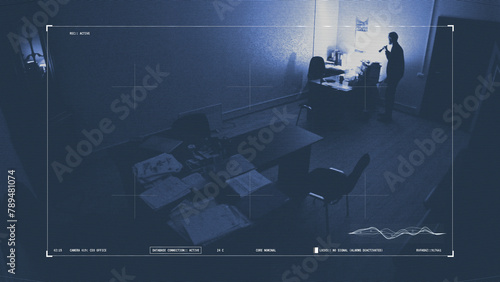 Man trespasses in an office at night, searching for insider business data, under surveillance  photo