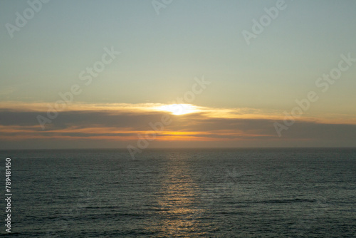 Seascape. Panorama view of the hiding sun and ocean weaves at sunset