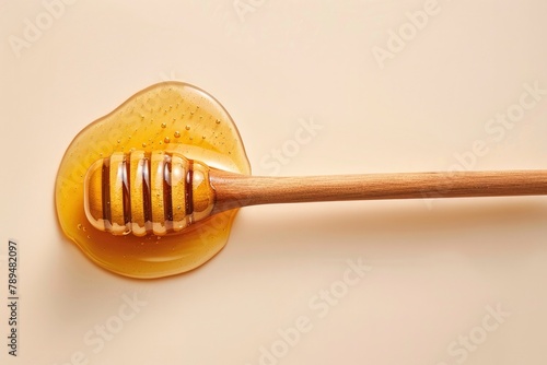 A wooden stick with honey oozing over a white background